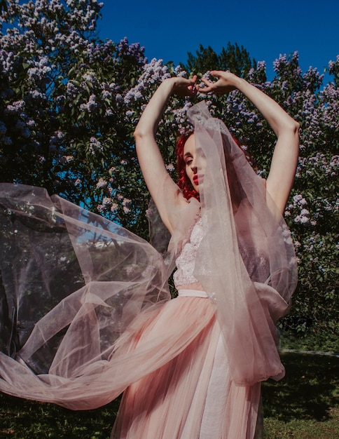 Jeune femme en robe rose dans le jardin