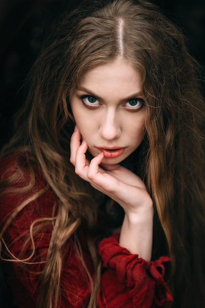 Jeune femme en robe rouge dans la forêt d'automne