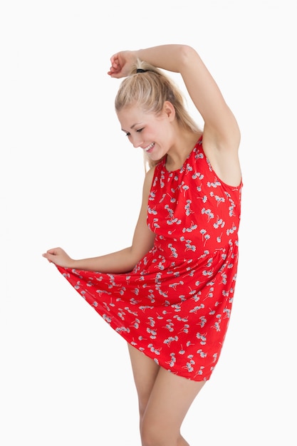 Jeune femme en robe rouge d&#39;été dansant