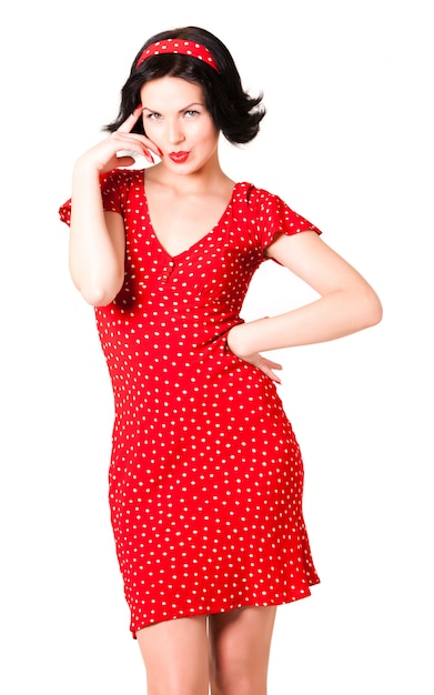 Jeune femme en robe vintage rouge debout sur blanc