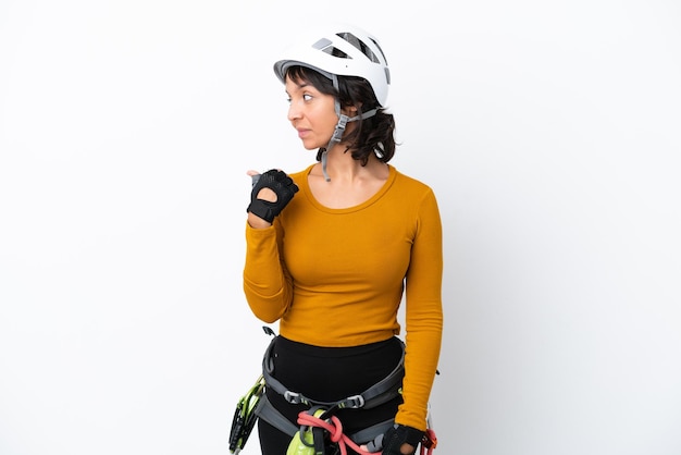 Jeune femme rockclimber femme isolée sur fond blanc pointant vers le côté pour présenter un produit