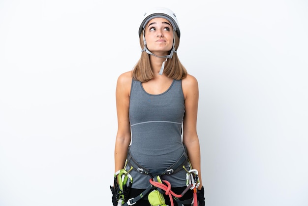 Jeune femme rockclimber isolée sur fond blanc et levant les yeux