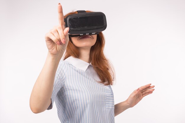 Jeune femme rousse à l'aide de lunettes de réalité virtuelle