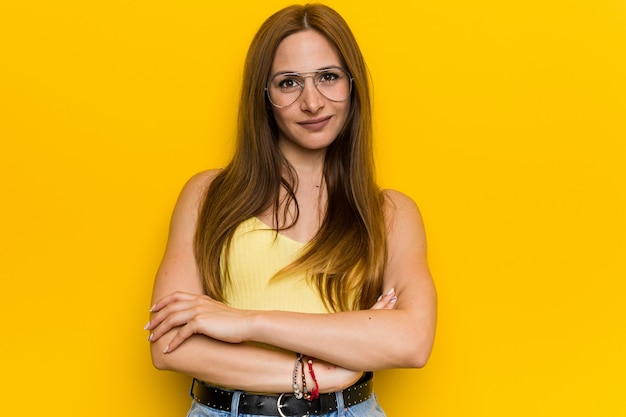 Jeune femme rousse au gingembre sans tache qui se sent confiante, les bras croisés avec détermination.