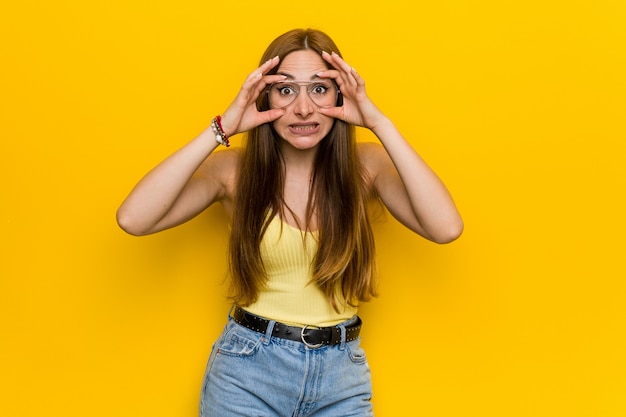 Jeune femme rousse au gingembre avec des taches de rousseur gardant les yeux ouverts pour trouver une occasion de réussir