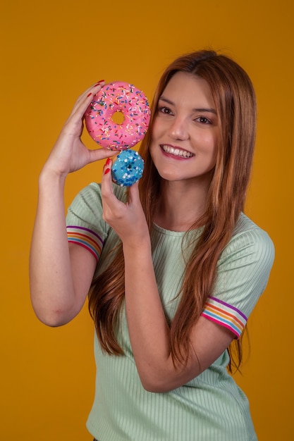 Jeune femme rousse avec des beignets