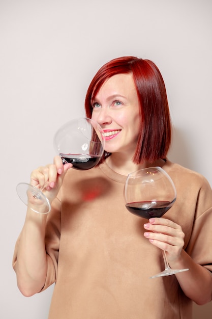 Jeune femme rousse drôle sommelier avec verres à vin