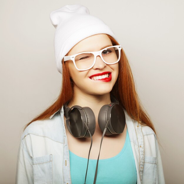 Jeune femme rousse avec des écouteurs écoutant de la musique.