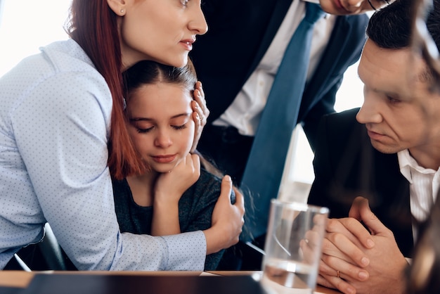 Jeune femme rousse étreignant une fille qui pleure.