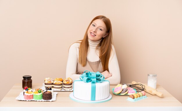 Jeune femme rousse avec un gros gâteau