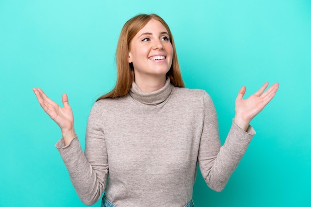 Jeune femme rousse isolée sur fond bleu souriant beaucoup