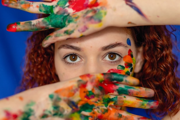 Photo jeune femme rousse joyeuse souillée de peinture colorée