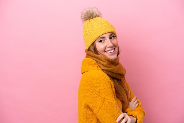 Jeune femme rousse portant une veste d'hiver isolée sur fond rose avec les bras croisés et heureux