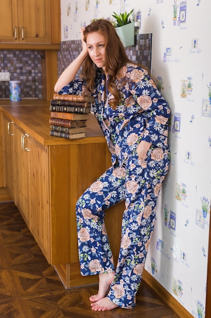 Jeune femme rousse se détendre à la maison avec des livres