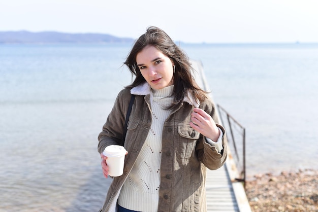 Jeune femme russe buvant du café contre la mer japonaise au printemps