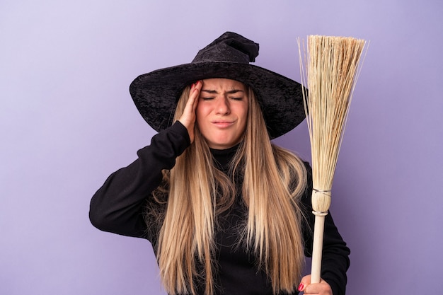 Jeune femme russe déguisée en sorcière tenant un balai isolé sur fond violet étant choquée, elle s'est souvenue d'une réunion importante.