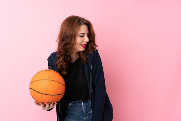 Jeune femme russe sur isolé avec ballon de basket