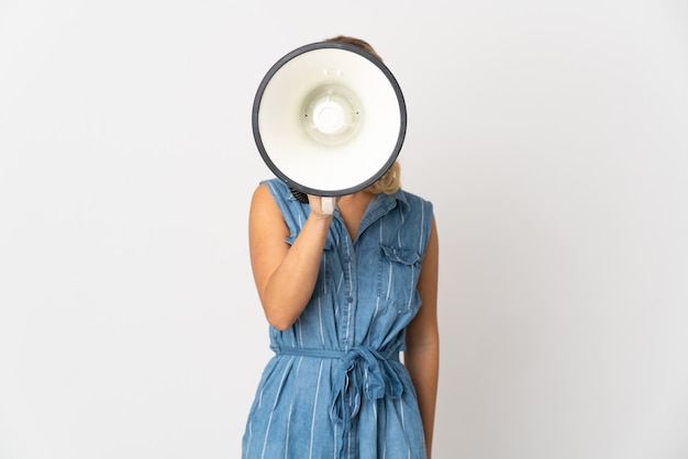 Jeune femme russe isolée sur fond blanc criant à travers un mégaphone pour annoncer quelque chose