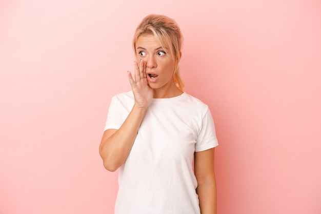 Jeune femme russe isolée sur fond rose choquée à cause de quelque chose qu'elle a vu.