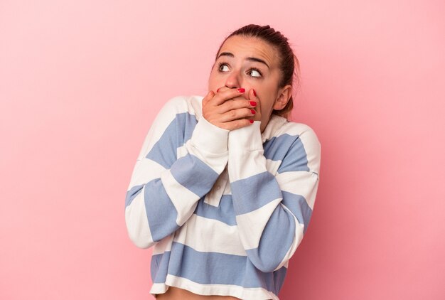 Jeune femme russe isolée sur fond rose choquée pointant avec l'index vers un espace de copie.