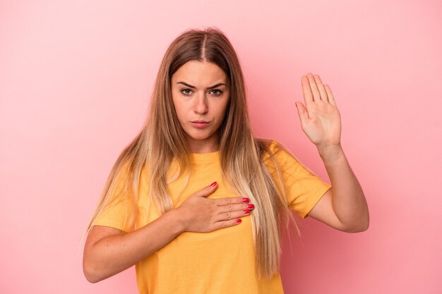 Jeune femme russe isolée sur fond rose couvrant les oreilles avec les doigts, stressée et désespérée par une ambiance bruyante.