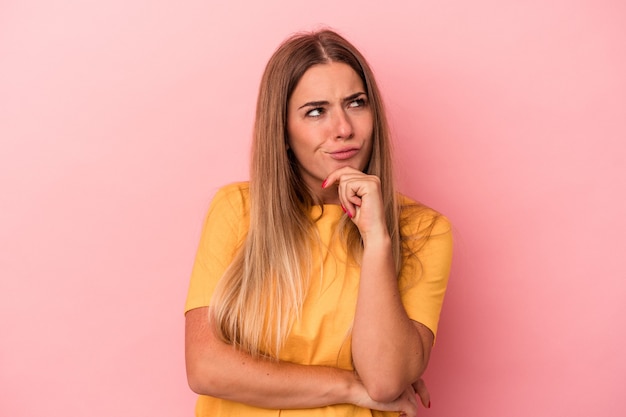 Jeune femme russe isolée sur fond rose levant le poing après une victoire, concept gagnant.