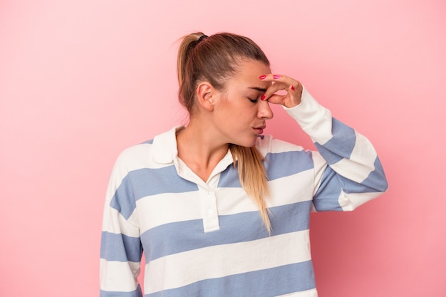 Jeune femme russe isolée sur fond rose montrant le pouce vers le bas, concept de déception.