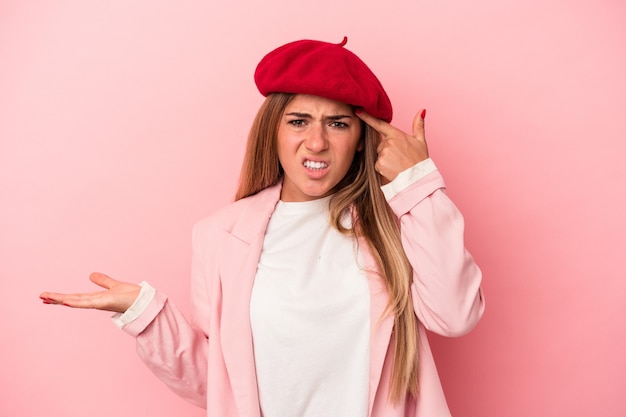 Jeune femme russe isolée sur fond rose souffrant d'un mal de dos.