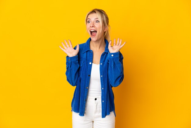 Jeune femme russe isolée sur jaune avec une expression faciale surprise