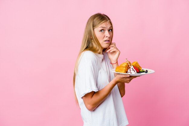 Jeune femme russe mangeant une gaufre isolée peur et peur.