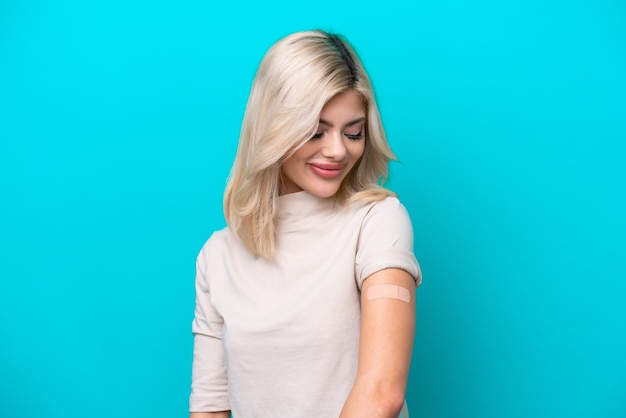 Jeune femme russe portant un pansement isolé sur fond bleu avec une expression heureuse