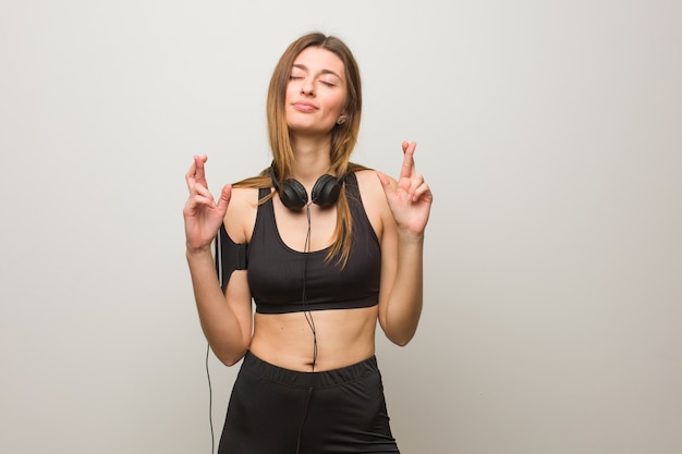 Jeune femme russe de remise en forme croise les doigts pour avoir de la chance