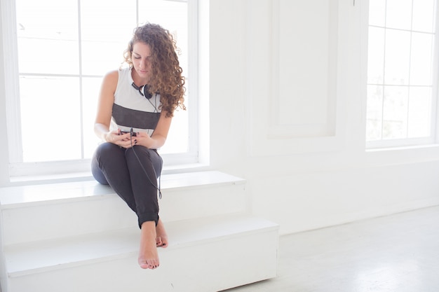 jeune femme, s'asseoir fenêtre, dans, salle blanche