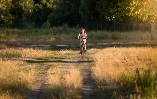 Jeune femme s'éloignant à vélo au pré