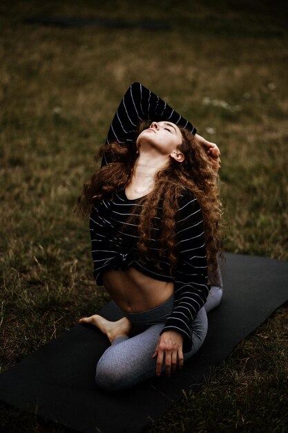 Photo une jeune femme s'étirant sur un tapis de yoga