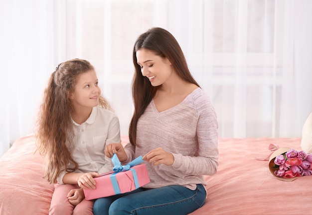 Jeune femme et sa fille avec boîte-cadeau à l'intérieur. Fête des mères