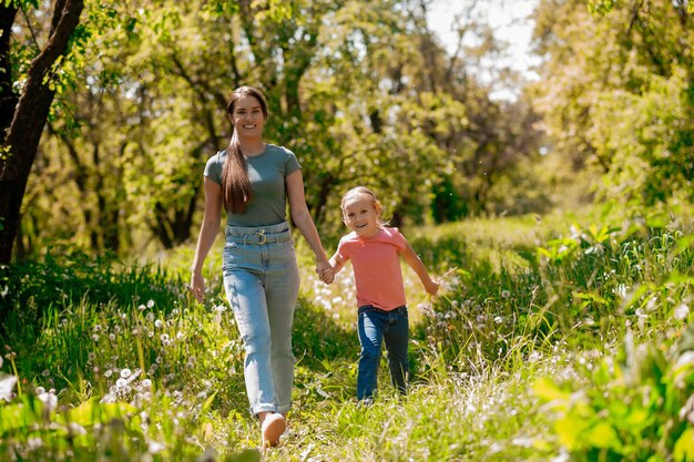 Jeune femme et sa fille marchant dans la forêt