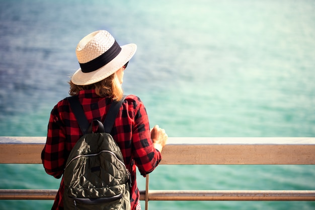 Photo une jeune femme avec un sac à dos est assis sur le pont piétonnier près du port d'alicante