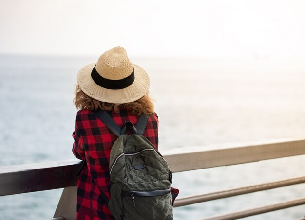 Une jeune femme avec un sac à dos est assis sur le pont piétonnier près du port d'Alicante