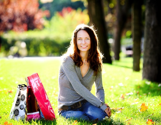 Jeune femme avec des sacs à provisions dans le parc d'été