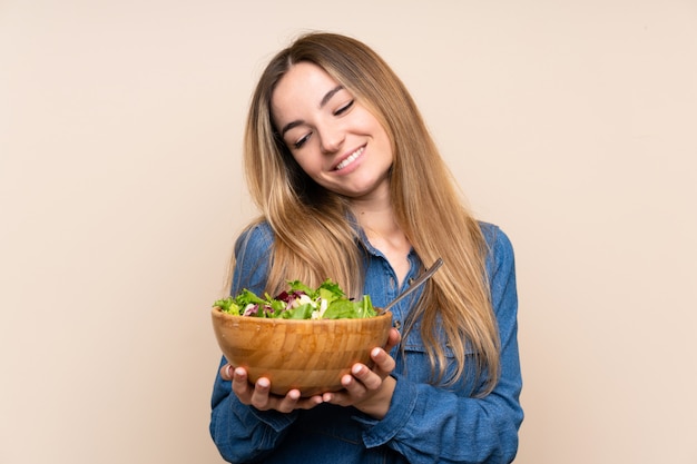 Jeune femme avec une salade sur fond isolé