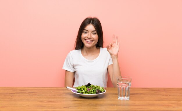 Jeune femme avec une salade montrer signe ok avec les doigts