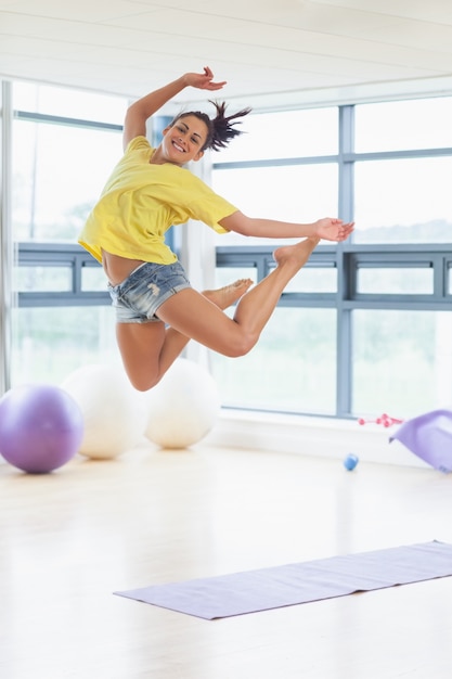 Jeune femme sautant dans un studio de remise en forme