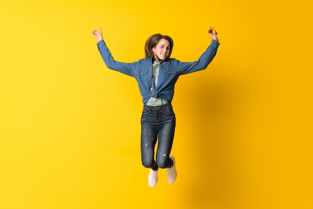 Jeune femme sautant par-dessus jaune