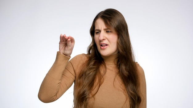 Photo jeune femme sceptique faisant un geste blabla avec la main