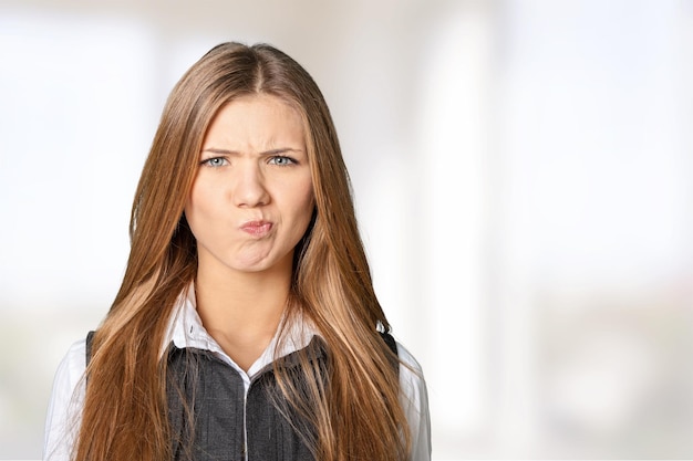 Jeune femme sceptique sur fond flou clair