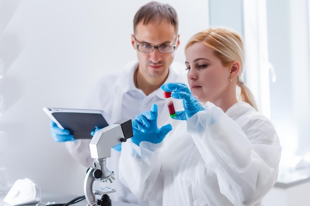 Jeune femme scientifique analysant l'échantillon en laboratoire