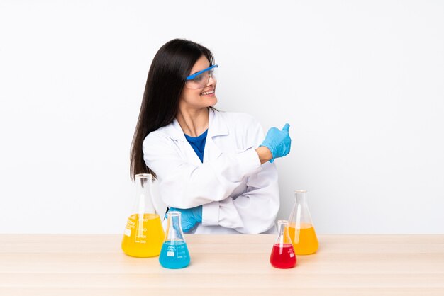 Jeune femme scientifique dans un tableau pointant vers l'arrière