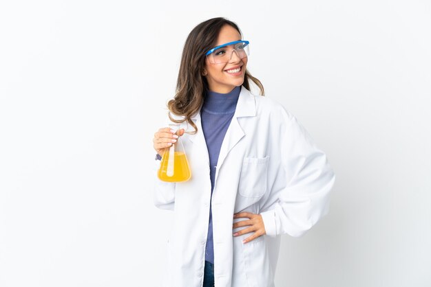 Jeune femme scientifique isolée sur un espace blanc posant avec les bras à la hanche et souriant