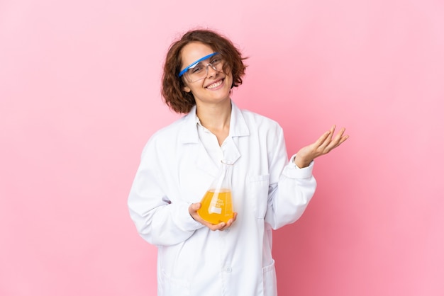 Jeune femme scientifique isolée étendant les mains sur le côté pour inviter à venir